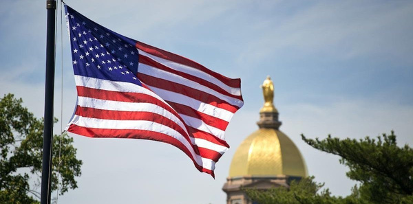 United States flag flying with the Golden Dome in the background