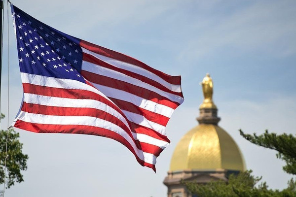 United States flag flying with the Golden Dome in the background